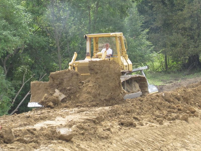Granger Construction operator pushing dirt with a Komatsu dozer to build a pond